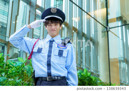 A young Japanese male security guard salutes. Photo courtesy of Denpa Gakuen Educational Foundation, Tokyo Electronics College. 138639343