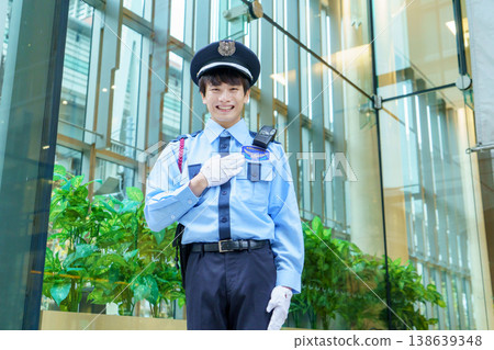 A young Japanese male security guard places his hand on his chest. Photo courtesy of Denpa Gakuen Educational Foundation, Tokyo Electronics College. A young Japanese male security guard places his hand on his chest. Photo courtesy of Denpa Gakuen Educational Foundation, Tokyo Electronics College. 138639348