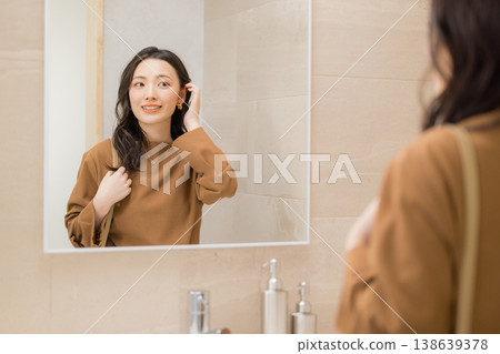 年輕女子在浴室檢查皮膚狀況 年輕女子在浴室檢查皮膚狀況 138639378