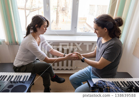 Emotional moment between two students in a music classroom. Friendship and support in college. 138639588