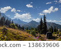 Off-road car navigating a rugged path in the mountains with glaciers and pine forests in the background. 138639606