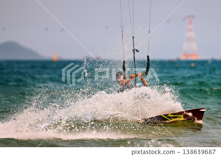 Kitesurfer Cutting Through Waves in Open Sea Kitesurfer Cutting Through Waves in Open Sea 138639687