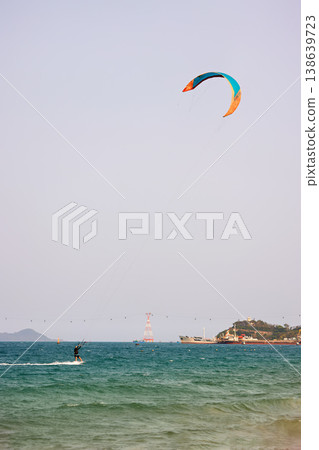 Kitesurfer Gliding on Water With Kite High Above Kitesurfer Gliding on Water With Kite High Above 138639723