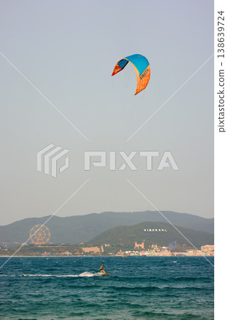 Kitesurfer Gliding on Water With Kite High Above Kitesurfer Gliding on Water With Kite High Above 138639724