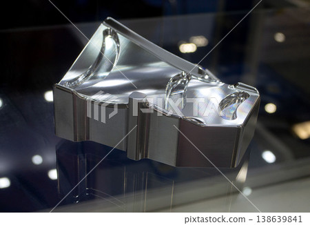 Metal part manufactured using CNC machining. Metal part made by metalworking CNC machine from a solid piece of metal. Polished aluminum or stainless steel. High-precision milling followed by polishing 138639841