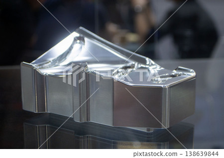 Metal part manufactured using CNC machining. Metal part made by metalworking CNC machine from a solid piece of metal. Polished aluminum or stainless steel. High-precision milling followed by polishing 138639844
