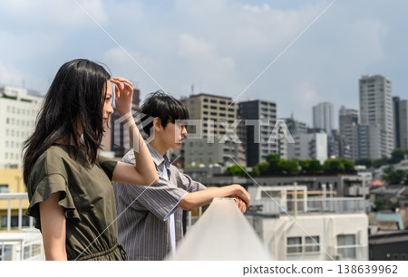 一男一女凝視著城市，避開陽光。 138639962