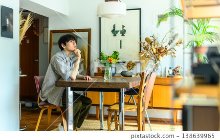 一個年輕人在窗邊陷入沉思。 138639965