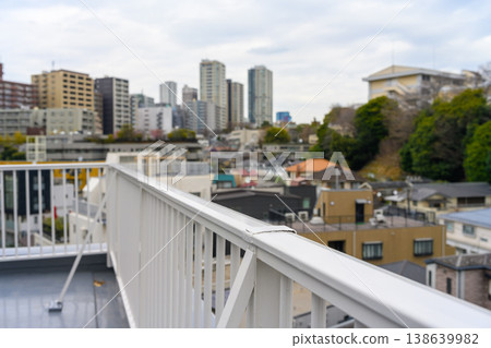 Cityscape and railings as seen from the rooftop 138639982