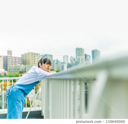 A man lost in thought on a rooftop in the city. 138640000