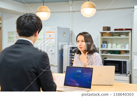 一位微笑的女商人正在辦公室休息室與一位男同事愉快地聊天。 一位微笑的女商人正在辦公室休息室與一位男同事愉快地聊天。 138640303