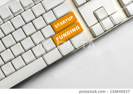 High-angle shot of a white computer keyboard featuring two prominent orange keys labeled Startup and Funding, symbolizing business investment and entrepreneurial growth High-angle shot of a white computer keyboard featuring two prominent orange keys labeled Startup and Funding, symbolizing business investment and entrepreneurial growth 138640837