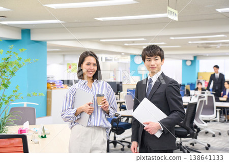 Business professionals, men and women, lined up with smiles on their faces, holding laptops in a brightly lit office. Business professionals, men and women, lined up with smiles on their faces, holding laptops in a brightly lit office. 138641133