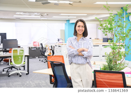 A businesswoman stands with a laptop in her hand, smiling. A businesswoman stands with a laptop in her hand, smiling. 138641369