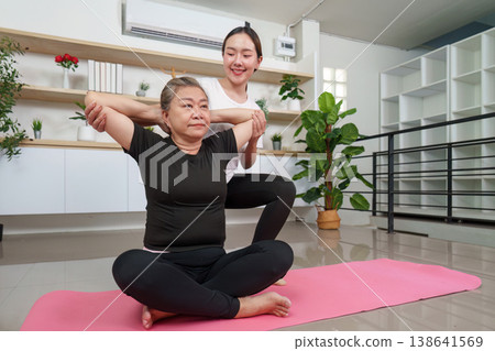 Yoga instructor assisting senior woman in stretching exercise Yoga instructor assisting senior woman in stretching exercise 138641569