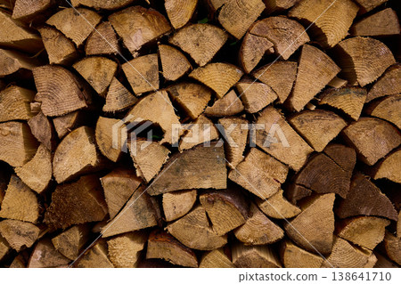 Stacked firewood displayed in a neat arrangement for winter use, showing various cuts and textures during daytime Stacked firewood displayed in a neat arrangement for winter use, showing various cuts and textures during daytime 138641710