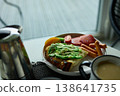 Enjoying avocado toast with coffee and sides at a cozy cafe in the morning light 138641735