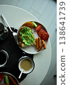 Enjoying avocado toast with coffee and sides at a cozy cafe in the morning light 138641739