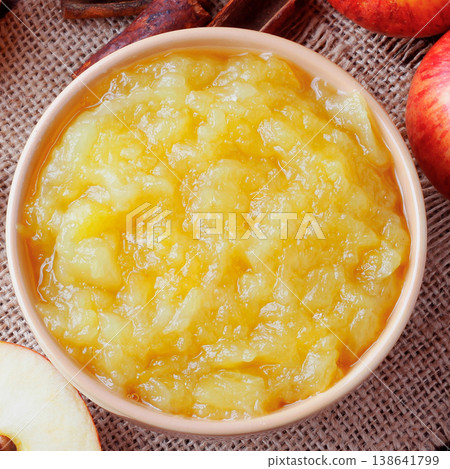 homemade apple sauce or apple puree in ceramic bowl over rustic wooden table. top view homemade apple sauce or apple puree in ceramic bowl over rustic wooden table. top view 138641799