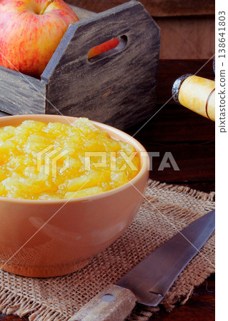 homemade apple sauce or apple puree in ceramic bowl over rustic wooden table. top view homemade apple sauce or apple puree in ceramic bowl over rustic wooden table. top view 138641803