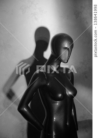 A glittering black mannequin against a dirty wall. A glittering black mannequin against a dirty wall. 138641998