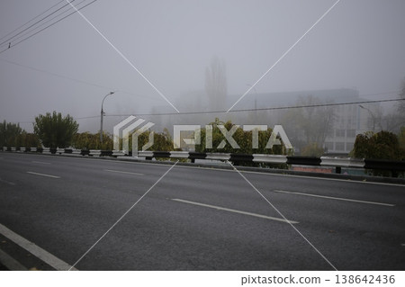 An asphalt road next to a metal bump. 138642436