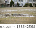 The dilapidated schoolyard of a closed elementary school. Puddles on the field after the rain, and the remaining soccer goal. A winter scene. 138642568