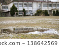 The dilapidated schoolyard of a closed elementary school. Puddles on the field after the rain, and the remaining soccer goal. A winter scene. 138642569