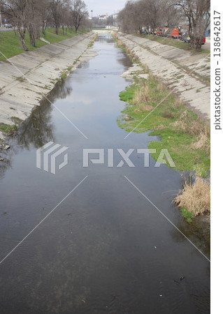 An overgrown river that flows through the city. An overgrown river that flows through the city. 138642617