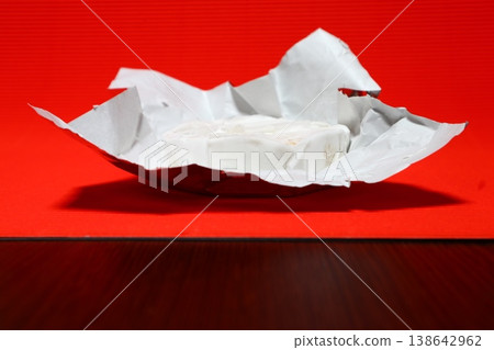 Brie cheese in foil packages. 138642962