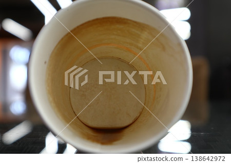 A dirty paper cup of coffee. 138642972