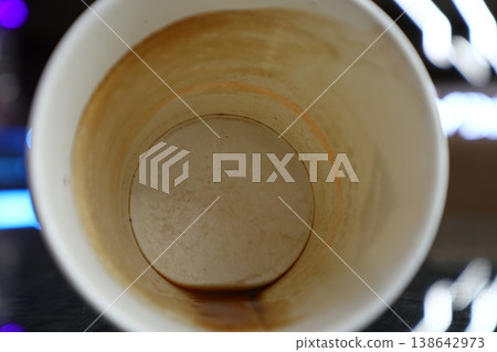 A dirty paper cup of coffee. 138642973