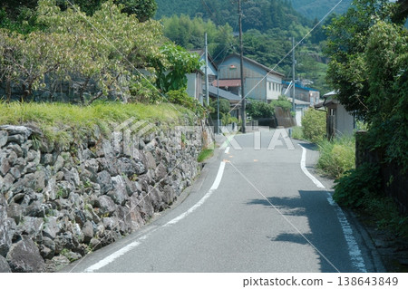 A summer scene on a country road: A quiet path through lush green mountains. A summer scene on a country road: A quiet path through lush green mountains. 138643849