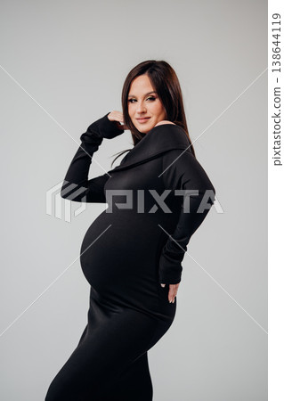 Expecting mother poses confidently in stylish outfit Expecting mother poses confidently in stylish outfit 138644119