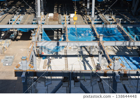 Workers performing high-altitude work and erection work at a steel frame construction site. Logistics facility new construction project 2 Workers performing high-altitude work and erection work at a steel frame construction site. Logistics facility new construction project 2 138644448