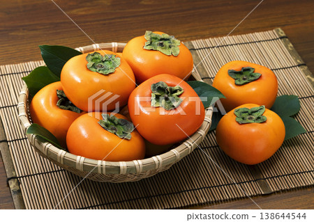 Persimmons in a colander Persimmons in a colander 138644544