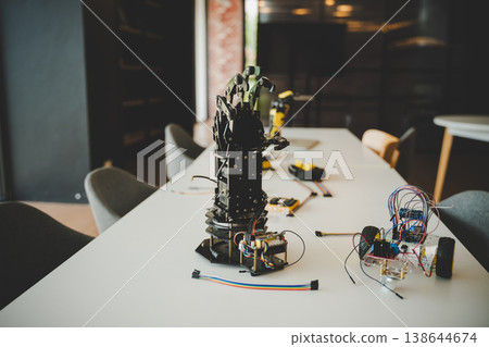 Robotic arm and circuit board on classroom table for hands-on STEM engineering education project 138644674