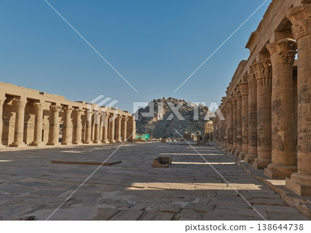 The ancient Egyptian landscape overlooking the courtyard and colonnades of the Temple of Philae and the rocky hills. The ancient Egyptian landscape overlooking the courtyard and colonnades of the Temple of Philae and the rocky hills. 138644738