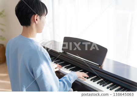 A man playing an electronic piano at home A man playing an electronic piano at home 138645063