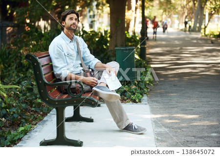 Man, tourist and map on bench in park outdoor for travel, direction or location for explore in nature. Person, photography or paper on lap for adventure, journey or photographer with exploration 138645072
