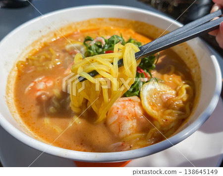 Laksa noodles, a Chinese noodle dish with shrimp and green onions. A close-up of the noodles. 138645149
