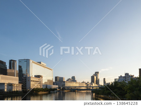The rising sun reflected on the water and modern buildings The rising sun reflected on the water and modern buildings 138645228