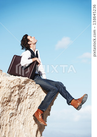 Thinking, cliff and happy business man for freedom, opportunity and career success in nature. Professional, sitting and corporate worker on rocks edge for holiday, relaxing and break with blue sky Thinking, cliff and happy business man for freedom, opportunity and career success in nature. Professional, sitting and corporate worker on rocks edge for holiday, relaxing and break with blue sky 138645236