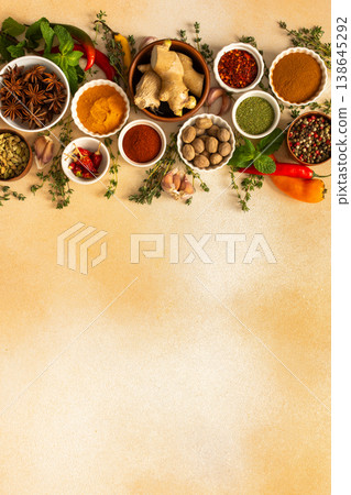 A colorful array of dried spices and fresh herbs arranged on a soft beige background, ideal for seasoning and adding rich flavor to dishes, top view and copy space 138645292