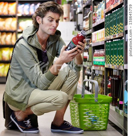 Man, label or product supermarket for choice, unhappy and disagree nutrition decision fail. Male person, shock or bottle shelf store or wholesale purchase, diet health value or buy organic consumer 138645759