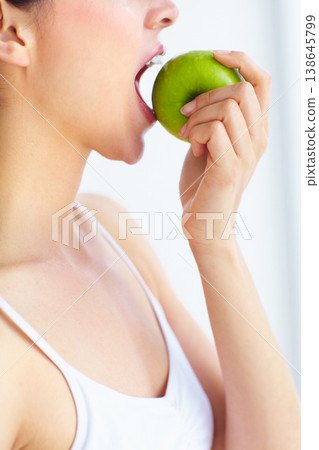 Closeup, eating and woman with health, apple or wellness with detox on a white studio background. Person, girl or model with fruit, nutrition or hungry with diet plan, food or natural with digestion Closeup, eating and woman with health, apple or wellness with detox on a white studio background. Person, girl or model with fruit, nutrition or hungry with diet plan, food or natural with digestion 138645799