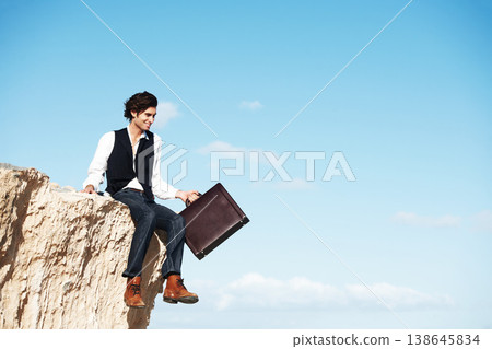 Blue sky, cliff and business man sitting for freedom, holiday and vacation to relax in nature. Professional, banner and corporate worker on rocks with briefcase for mindset, break and happiness Blue sky, cliff and business man sitting for freedom, holiday and vacation to relax in nature. Professional, banner and corporate worker on rocks with briefcase for mindset, break and happiness 138645834