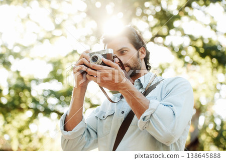 Picture, photographer or man in park on holiday vacation trip for creativity, shooting or tourism memory. Photography, travel or male tourist with camera for sightseeing or trees in nature in summer Picture, photographer or man in park on holiday vacation trip for creativity, shooting or tourism memory. Photography, travel or male tourist with camera for sightseeing or trees in nature in summer 138645888