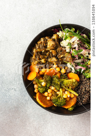 A wholesome breakfast of black quinoa, avocado, baked chicken, roasted vegetables like sweet potato, zucchini, and broccoli, along with a fresh salad of cabbage, radish, and chia seeds 138645894
