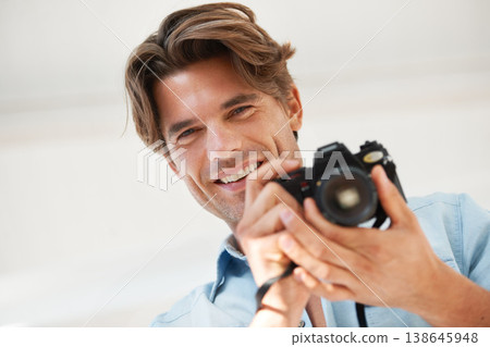Production, camera and portrait of man photographer at a photoshoot for creative work project. Happy, photography and handsome young male person with dslr device for art career by white background. Production, camera and portrait of man photographer at a photoshoot for creative work project. Happy, photography and handsome young male person with dslr device for art career by white background. 138645948